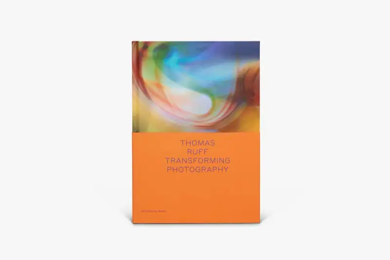Okładka książki "Thomas Ruff: Transforming Photography" z abstrakcyjnym, kolorowym wzorem i pomarańczowym spodem.